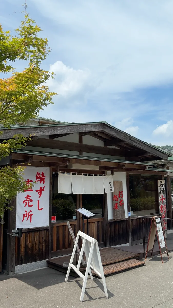 (左)鯖街道沿いの外観/(右)入口の前で回っている石臼
