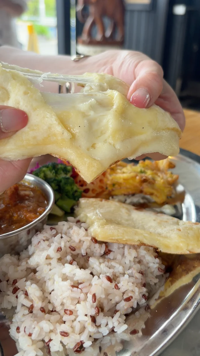 (左)タンドール窯。生地を内側の壁に貼りつけて焼きます/(右)6月に入っていたチーズナン。2026年7月からは、標準がプレーンナンに変わりました