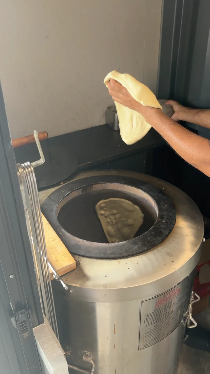 (左)タンドール窯。生地を内側の壁に貼りつけて焼きます/(右)6月に入っていたチーズナン。2026年7月からは、標準がプレーンナンに変わりました